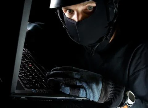 Computer theft on laptop at night Foto stock