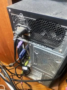 Computer tower rear view showing power supply, various cable connections, and Stock Photos