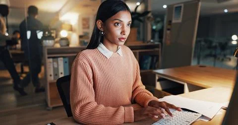 Computer, typing and planning with business woman in office for night, revenue Stock Photos