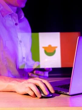 Computer user with green-white-red flag and orange circle overlay in glowin.. Stock Photos