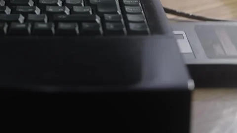 Computer user inserts outdated floppy disc data storage into laptop Stock Footage 311569117