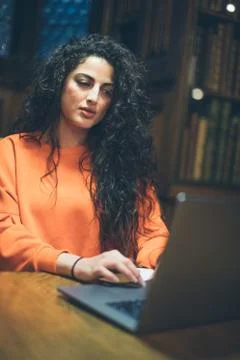 Computer using woman in old library room. Stock Photos