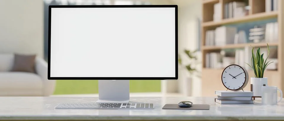 A computer with a white screen mockup and decor on a white table in a conte.. Stock Photos