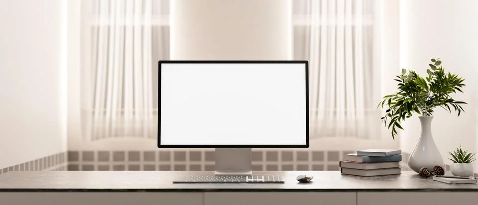 A computer with a white screen mockup and decor on a table in a minimalist .. Stock Photos
