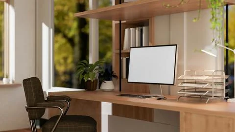 A computer with a white screen mockup sits on a wooden table in a contempor.. Foto stock