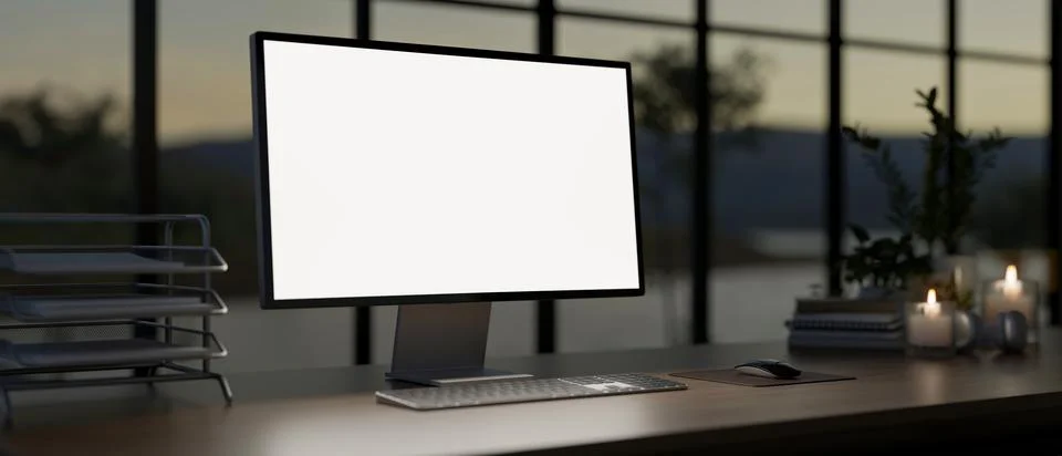 A computer with a white-screen mockup on a table against the window in a mo.. Illustrazione stock
