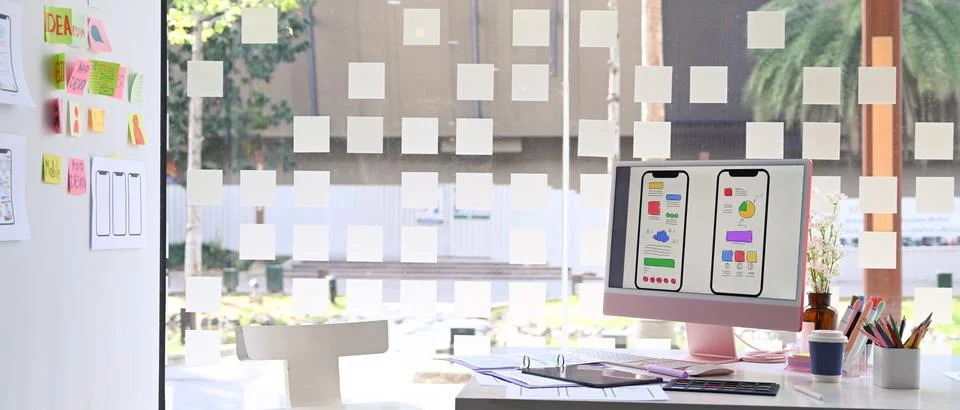 Computer with wireframe, sketches of mobile application on screen, document and Stock Photos