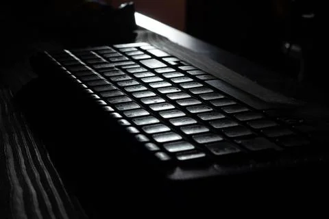 Computer wireless keyboard on wooden table background on the office in moonlight Stock Photos