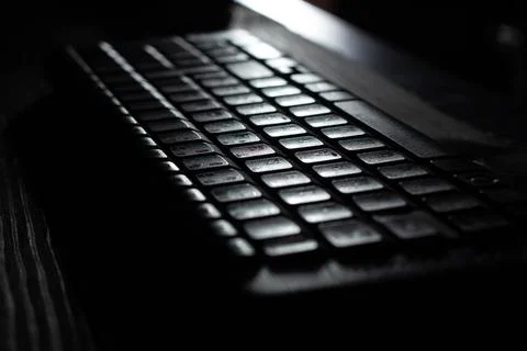 Computer wireless keyboard on wooden table background on the office in moonlight Foto stock