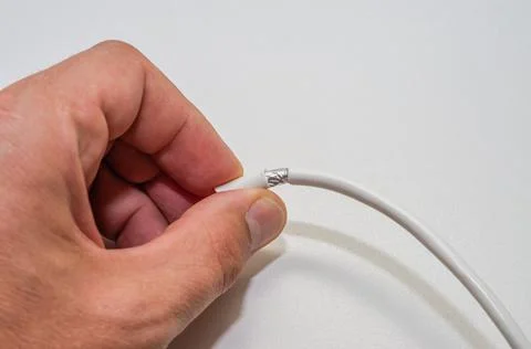 A computer wizard strips the wires of an Internet cable for connecting a twisted Stock Photos
