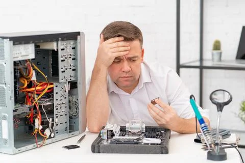 Computer workshop. professional services. sad repairman with a processor in hand Stock Photos