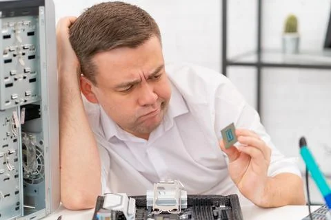 Computer workshop. professional services. sad repairman with a processor in hand Stock Photos