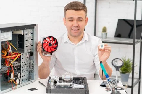 Computer workshop. repairman with a processor and cooler in hand 写真素材