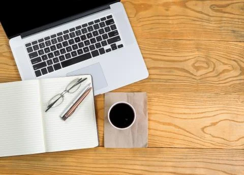 Computer with writing tools and dark coffee on top of desktop Stock-Fotos