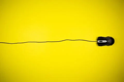 Computer yellow mouse with a long wire on a yellow background Stock Photos