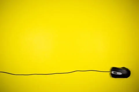 Computer yellow mouse with a long wire on a yellow background Stock Photos