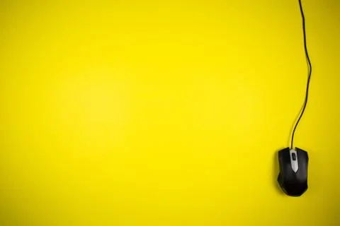 Computer yellow mouse with a long wire on a yellow background Foto stock