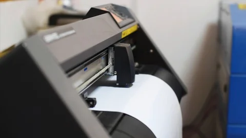 Computerized plotter machine cutting self-adhesive film in printing office. Stock Footage 114739161
