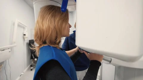 Computerized tomography in dentistry, woman standing in front X-ray machine Stock Footage 295750889