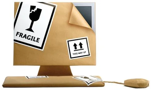 Computer,keyboard and mouse wrapped in brown paper isolated on a white backgr Stock Photos