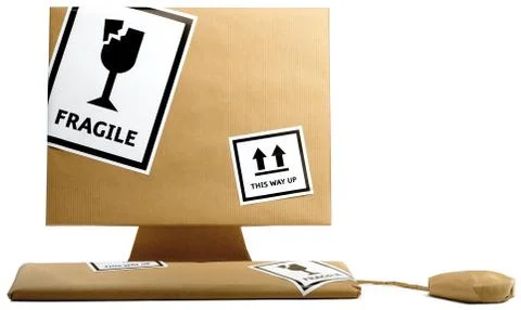 Computer,keyboard and mouse wrapped in brown paper isolated on a white backgr Stock Photos