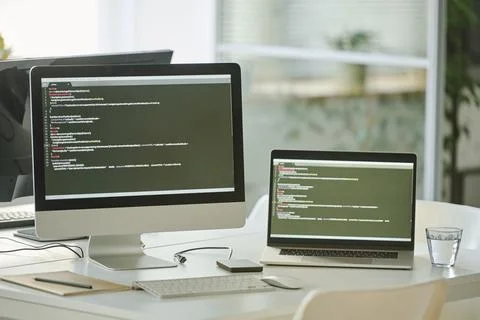 Computers with codes at office Stock Photos