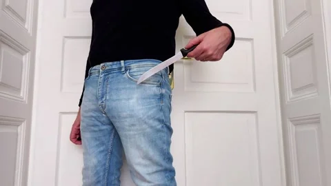 Concealing a Sharp Knife Inside a Blue Jeans Pocket Stock Footage 328368782