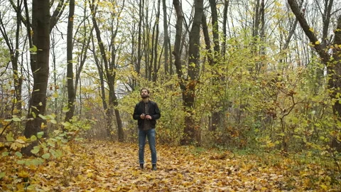 Conceived photographer walking in the autumn forest with a camera and Stock Footage 143074553
