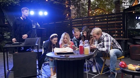 Concentraated young people sitting at the table and looking everyone into their Stock Footage 116662677