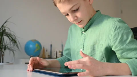 Concentraited teen boy programing using tablet at the table in classroom Stock Footage 168860355