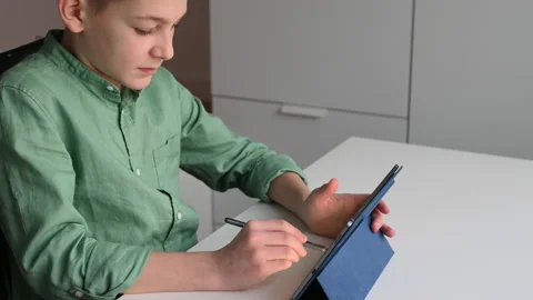 Concentraited teen boy programing using tablet at the table in classroom Stock-Footage 168869000
