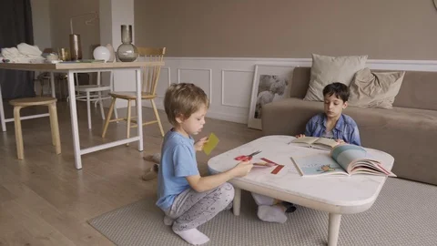 Concentrated 5 years boy cut paper with scissors passionately. Sticks out tongue Stock Footage 119533434