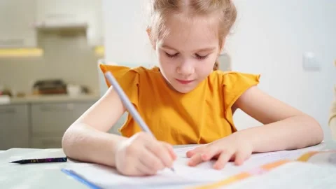 A concentrated and diligent schoolgirl does her homework. Vídeos de archivo 154322090