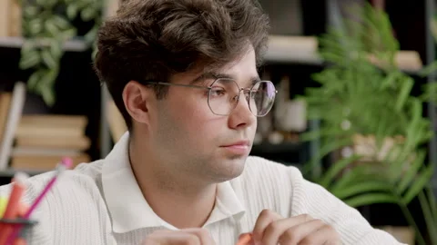 Concentrated and focused student learning online on a website. Young man with Stock Footage 316421551