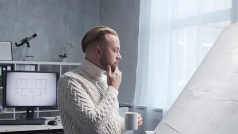 Concentrated architect works in loft using drawing board. Workplace of young Stock Footage 142581002