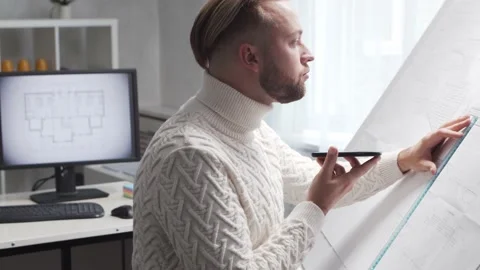 Concentrated architect works in loft using drawing board. Workplace of young Stock Footage 142581101