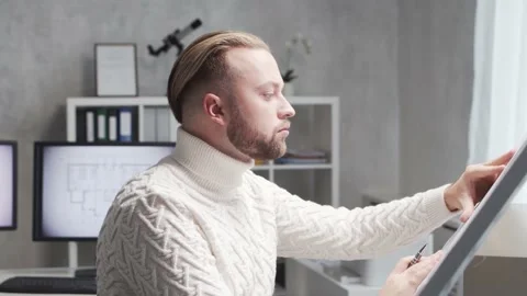 Concentrated architect works in loft using drawing board. Workplace of young Stock Footage 143030781