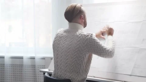 Concentrated architect works in loft using drawing board. Workplace of young Stock Footage 143033612