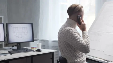 Concentrated architect works in loft using drawing board. Workplace of young Stock Footage 143770190