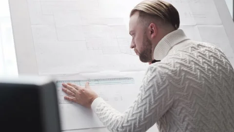 Concentrated architect works in loft using drawing board. Workplace of young Stock Footage 143865706