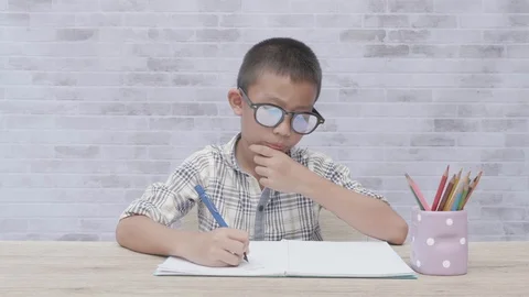 Concentrated asian boy doing homework. Stock Footage 117290049