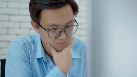Concentrated Asian Male Worker using a desktop computer Video stock 128246842