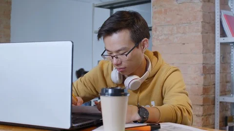 Concentrated Asian Man Writing Down with Pencil at Desk Stock Footage 126133744