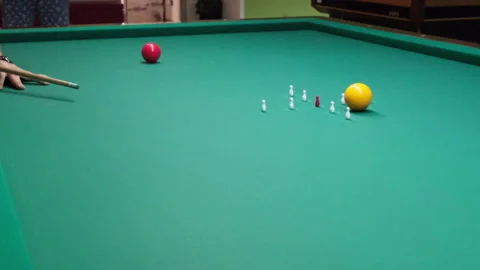 Concentrated athlete using cue on red white or yellow marble to hit target Stock Footage 316327919