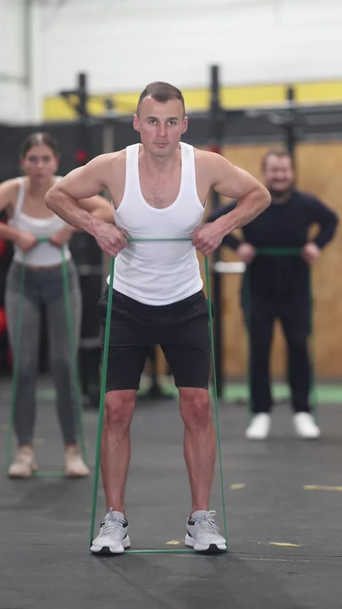Concentrated athletic young man exercising with resistance band loop during Stock Footage 288008694
