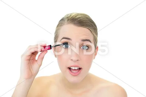 Concentrated attractive blonde applying mascara Stock Photos