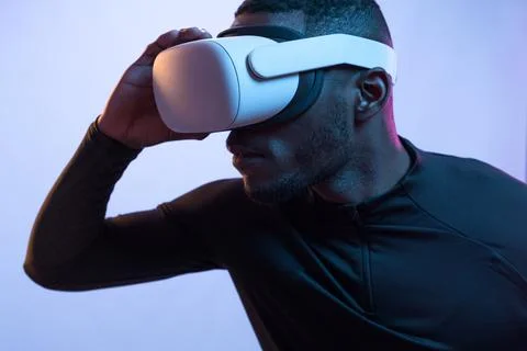 Concentrated black guy in VR headset looking away attentively Stock Photos