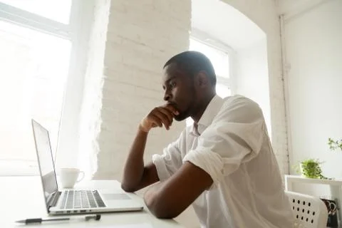 Concentrated black worker thinking about problem solution Foto stock