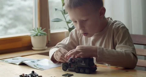Concentrated boy playing with erector set indoors close up slow motion. Portrait Stock Footage 146503351