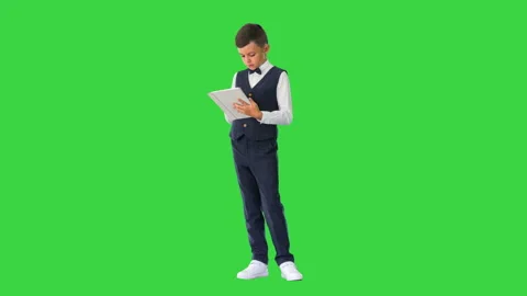 Concentrated boy using digital tablet while standing on a Green Screen, Chroma Vídeos de archivo 146464417